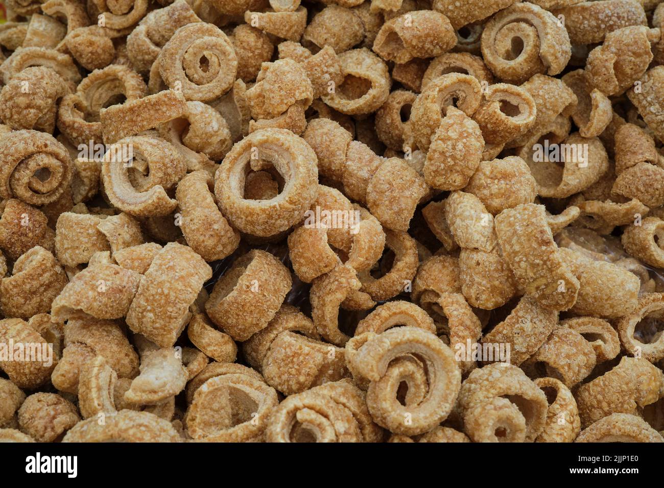 Top view of many coils of crispy fried bacon called torrezno placed in heap Stock Photo