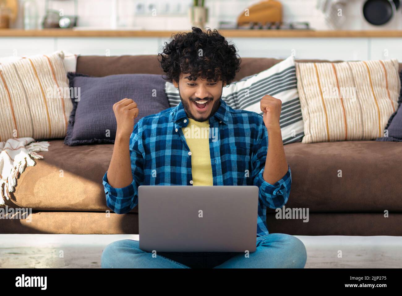 Portrait of excited young Asian man celebrating success Happy male freelancer working Stock Photo