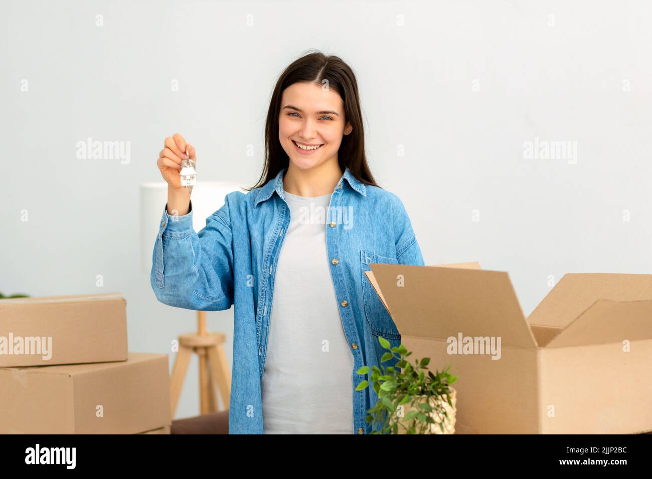 Young caucasian woman holding the keys in her hands while standing in her new house Moving concept Stock Photo