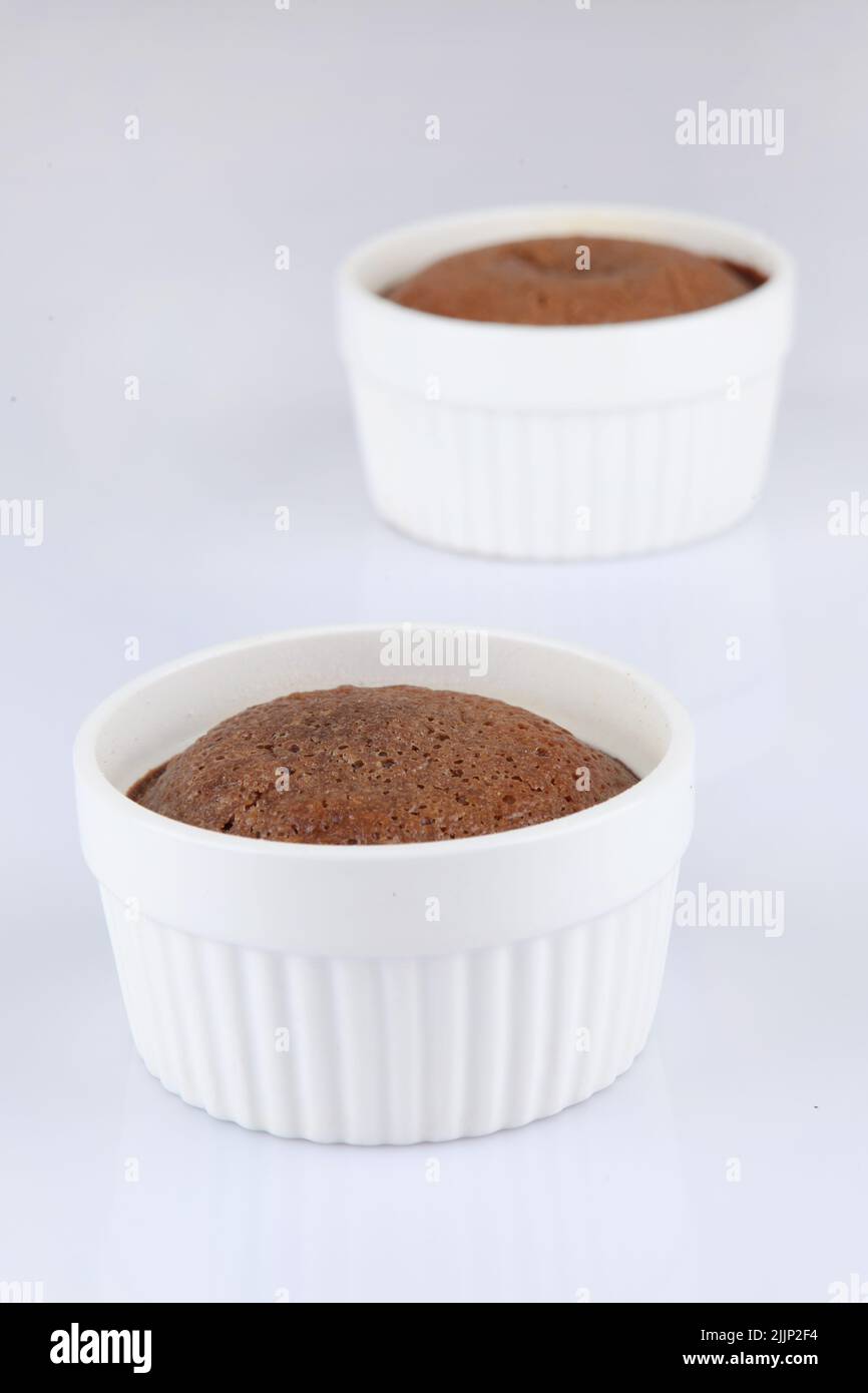A vertical shot of chocolate souffle in a classic white porcelain