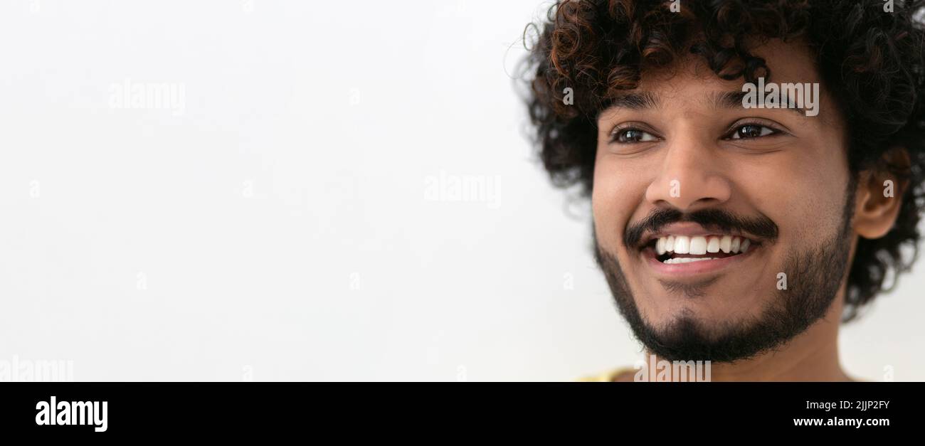 Portrait young happy positive Indian man smiling broadly on white background, copy space Stock Photo
