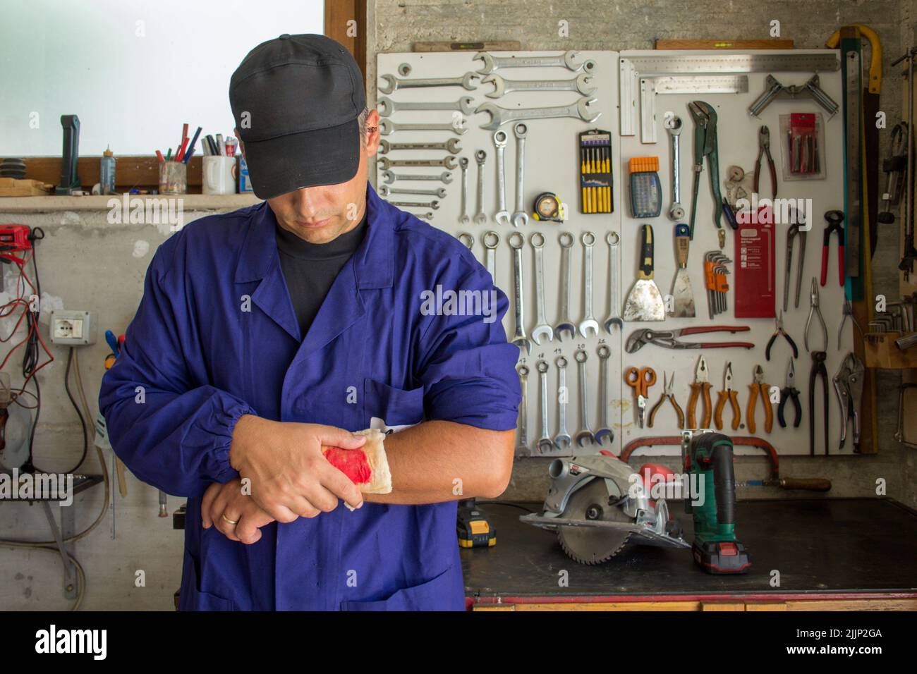 Image of a handyman with a bandaged wound on his arm. Reference to accidents at work Stock Photo