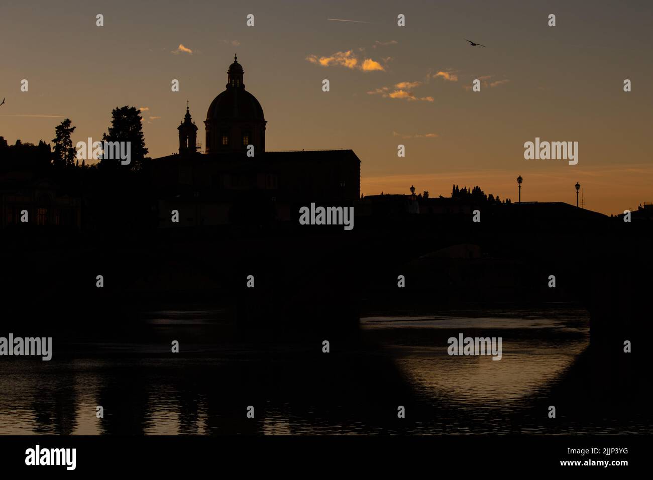 A silhouette of ancient buildings near the water in Florence, Italy Stock Photo