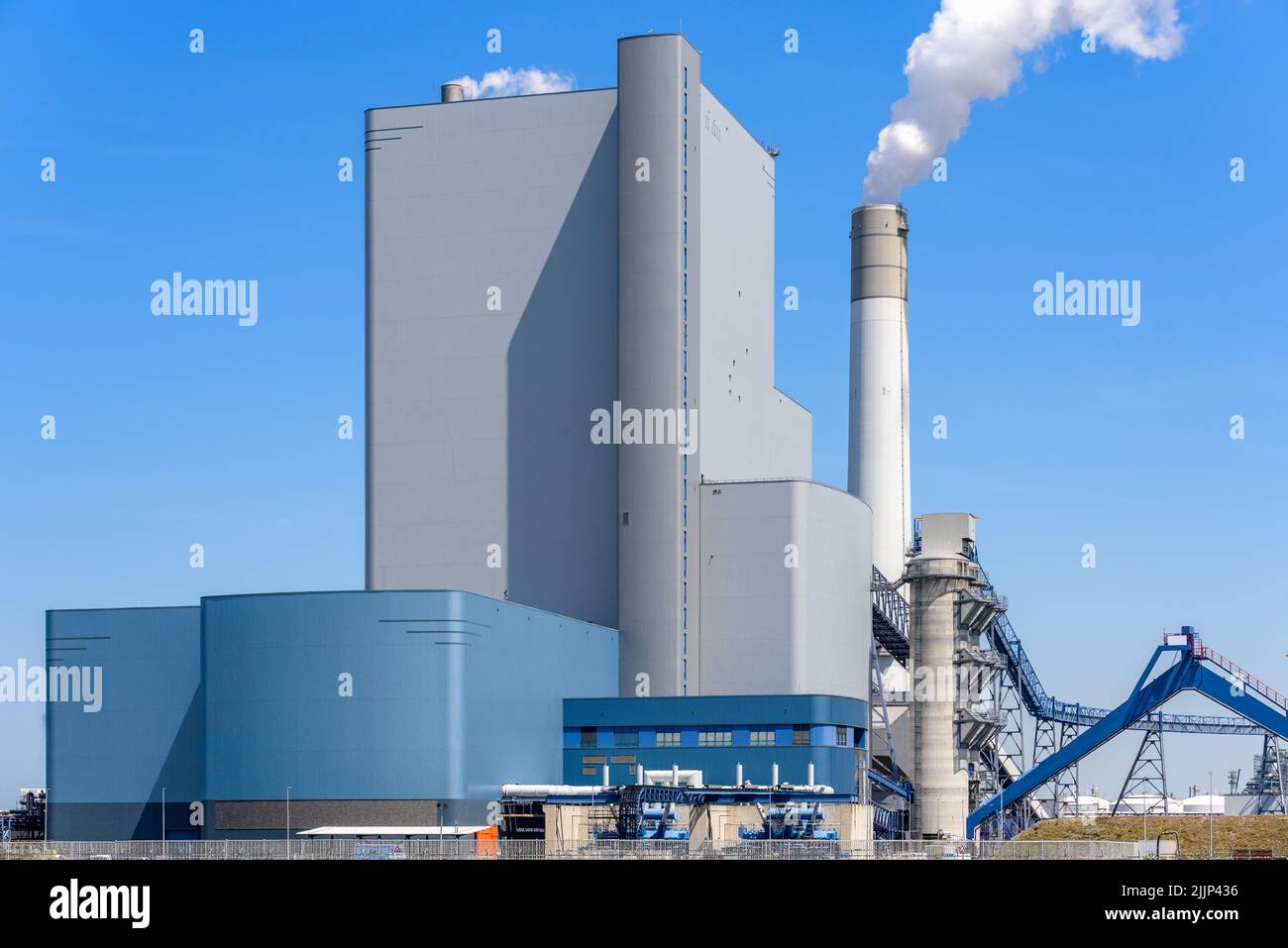 Power station running on coal and biomass for production of electricity and steam for heating under blue sky in summer Stock Photo
