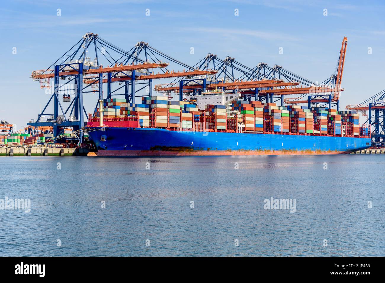 Large container ship in harbour on a sunny summer day Stock Photo
