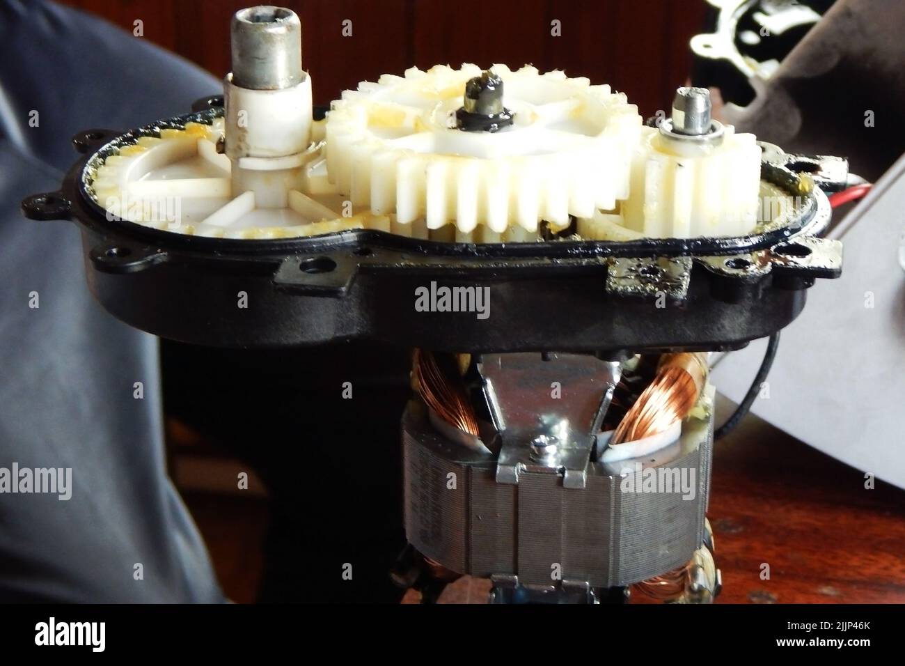 Plastic white gears of the mechanism in yellow grease Stock Photo Alamy