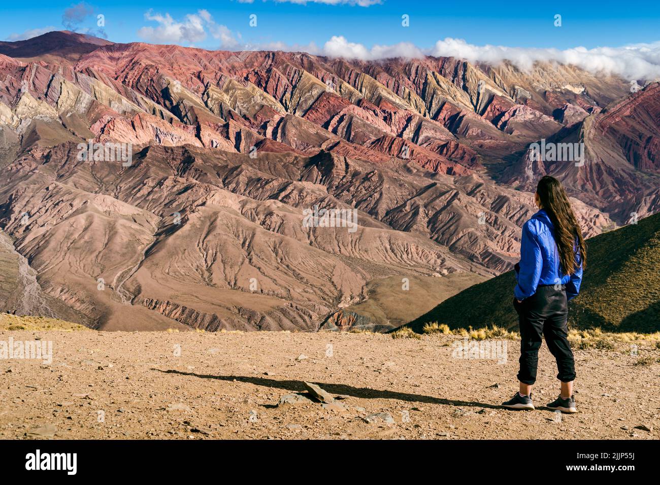 A woman standing and looking at Serrania de Ornocal mountains Stock Photo