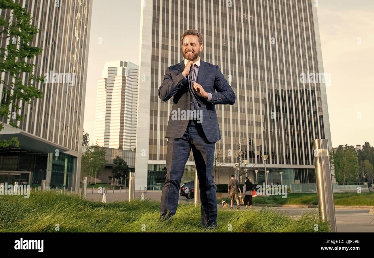 irritated businessperson in formalwear try to loosen the tie. business stress. Stock Photo