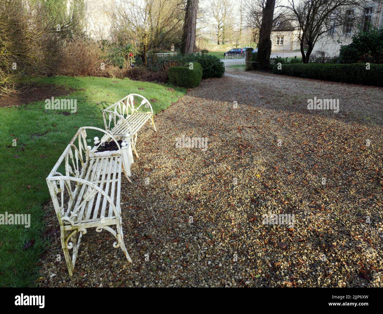 A view of white painted benches in a park Stock Photo