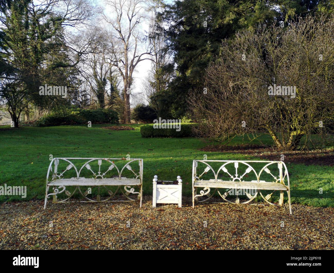 A view of white painted benches in a green park Stock Photo