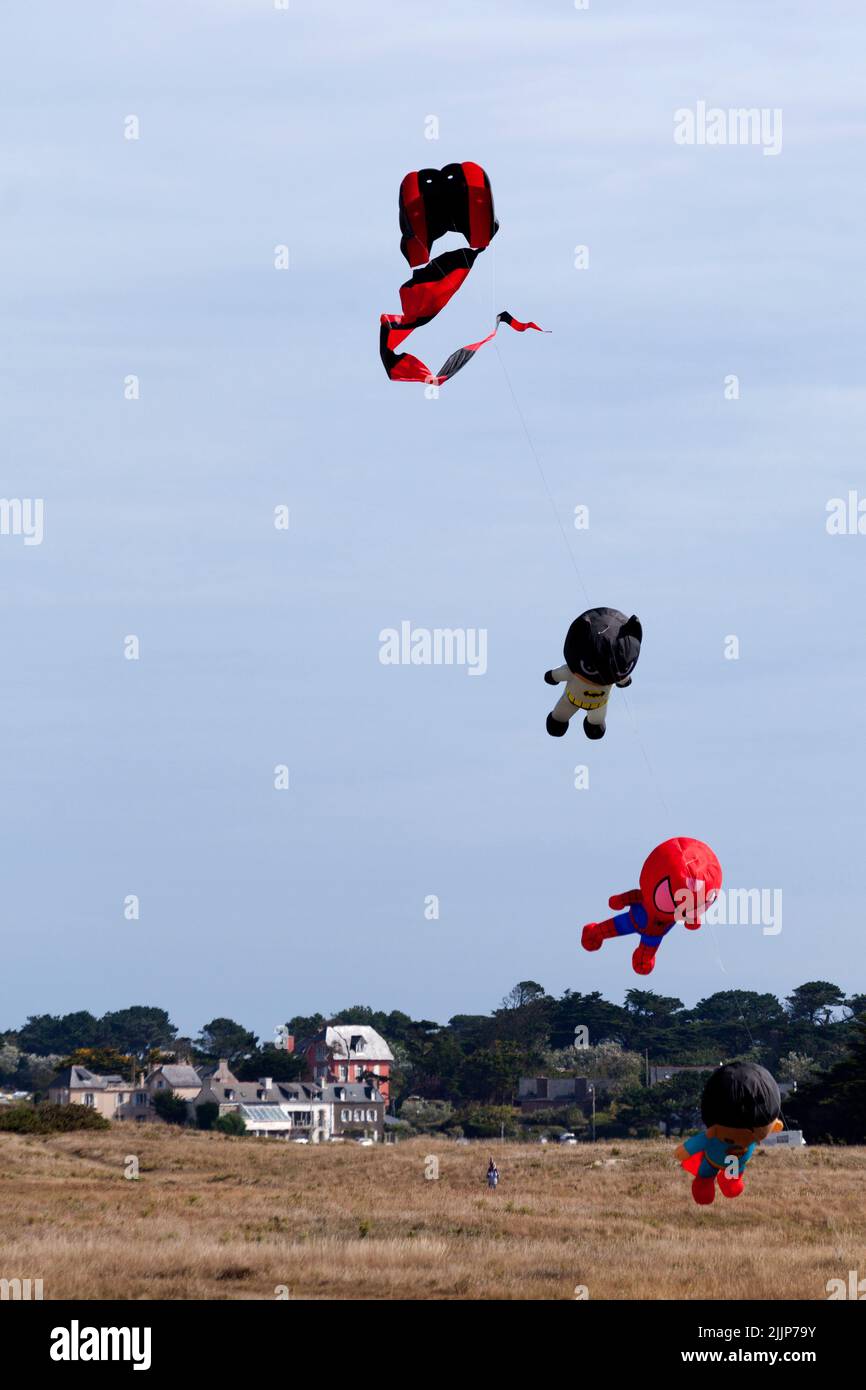 Porspoder, France - July 23 2022: Superhero-like kites flying in mid-air during the wind and kite festival in Porspoder, Brittany. Stock Photo