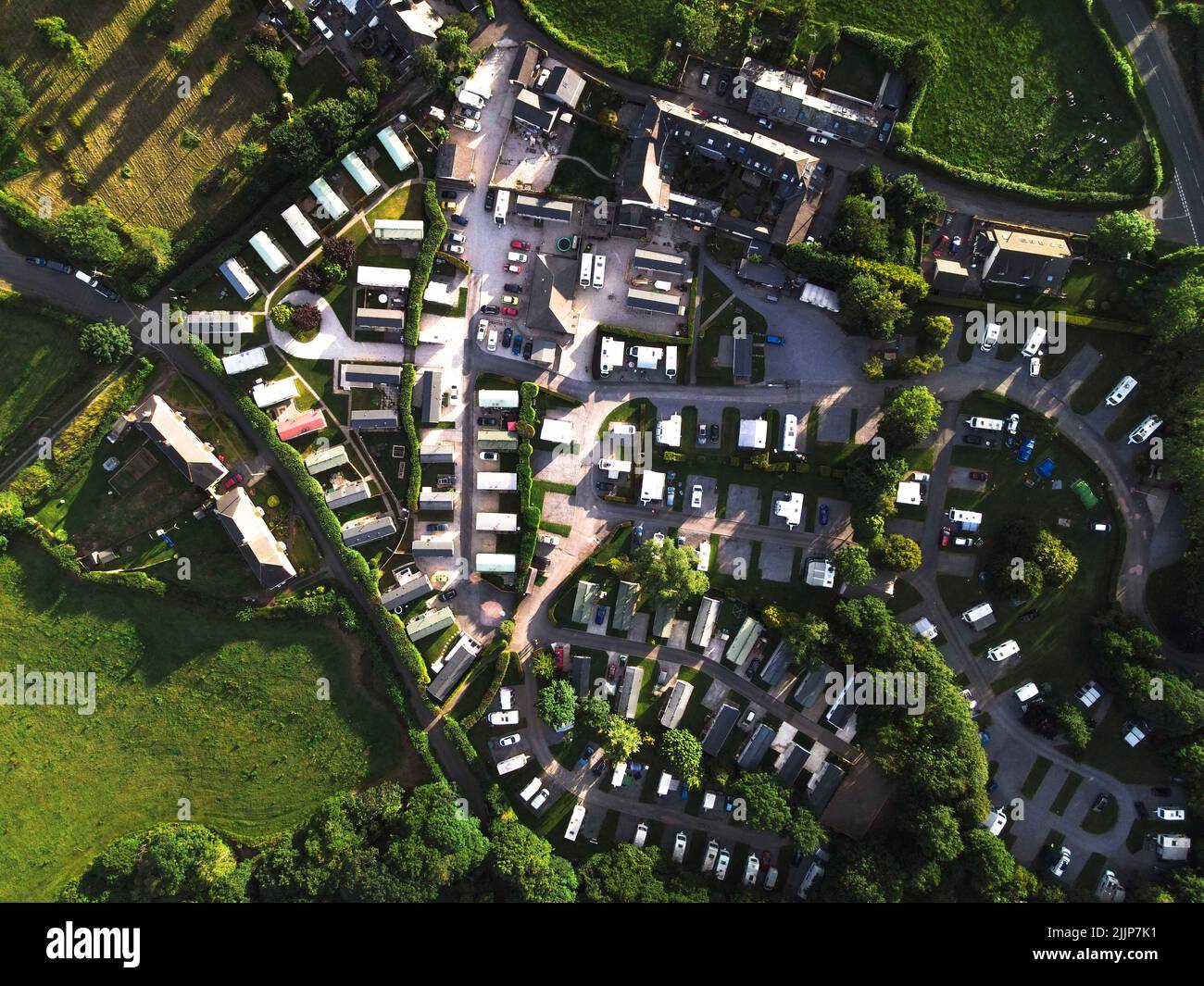 A bird's eye view of campsites surrounded by greenery fields and trees in Devon Stock Photo