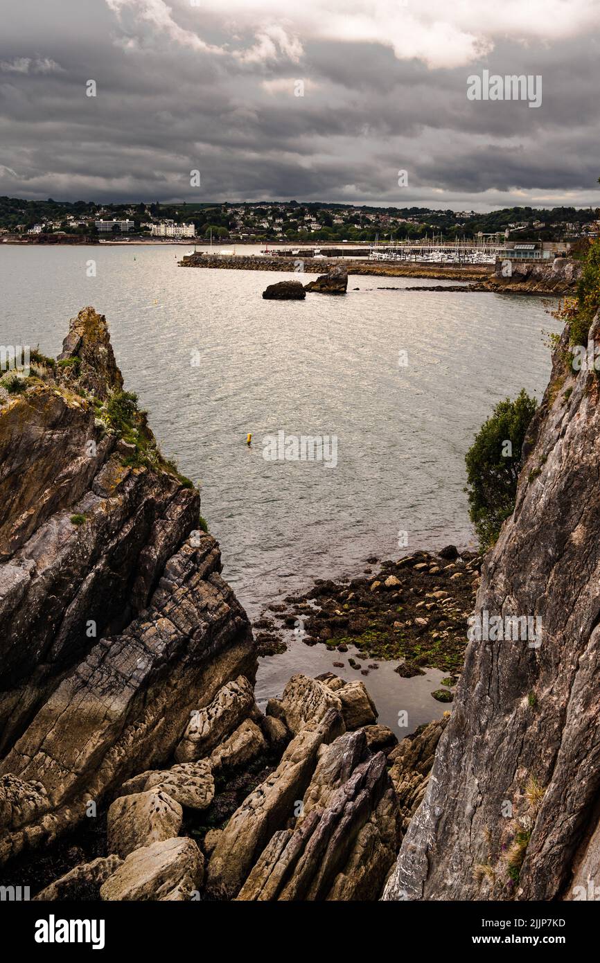 A vertical shot of rocky beach in background of buildings in Torquay Stock Photo