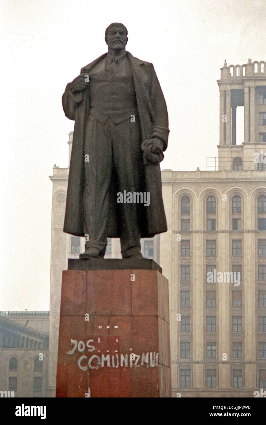 Bucharest, Romania, January 1990. On the pedestal of the statue of Lenin someone wrote 'Down with communism' in the days following the Romanian anticommunist revolution of December 1989, an unthinkable gesture before that time. The statue was standing in Piata Scanteii (The Spark Plazza ) since the 1960, and was eventually tore down in March 1990. Stock Photo