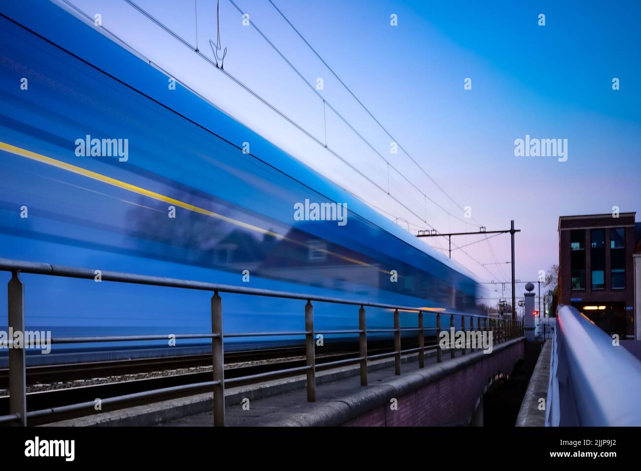 A train in motion at sunset or sunrise in Amersfoort, the Netherlands Stock Photo
