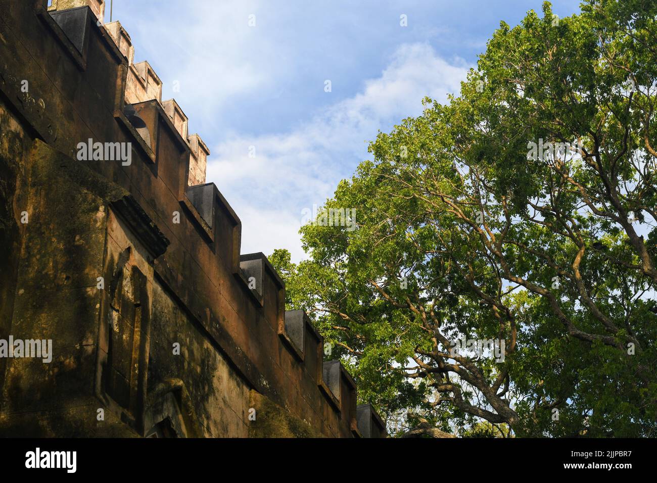 A low angle shot of the exterior wall of Fort of the Conception and the Triumph against blue cloudy sky in bright sunlight Stock Photo