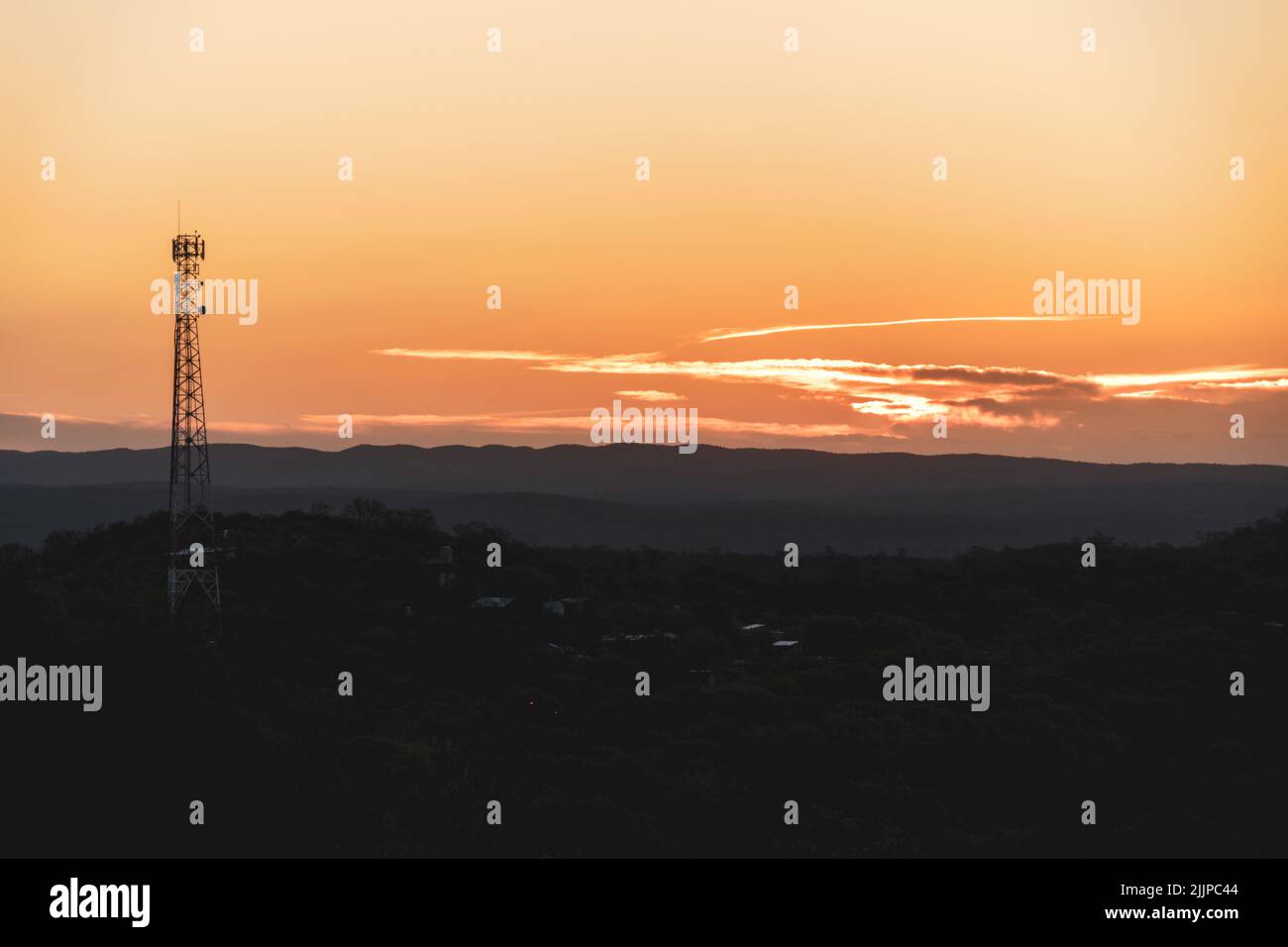 A beautiful landscape of a hill with a radio tower on the sunset Stock Photo