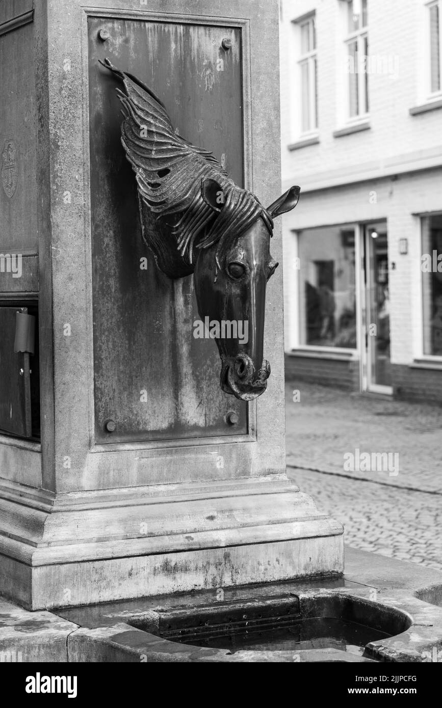 A vertical shot of a horse head water fountain in Brugge street, Belgium Stock Photo