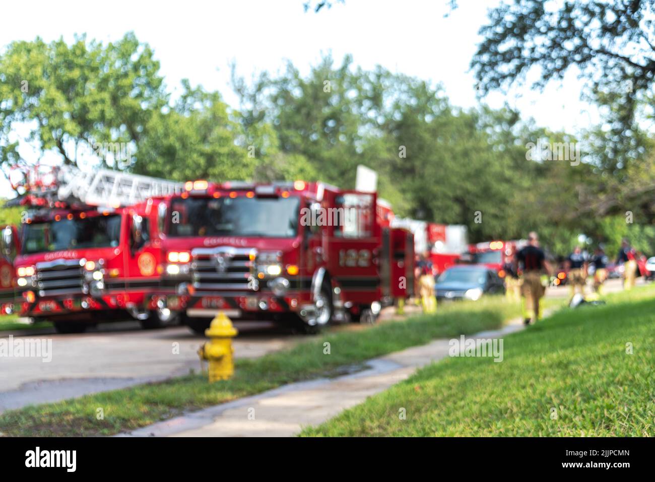 Red fire trucks with ladders and working firefighters at a residential house in suburbs Dallas, Texas, America Stock Photo