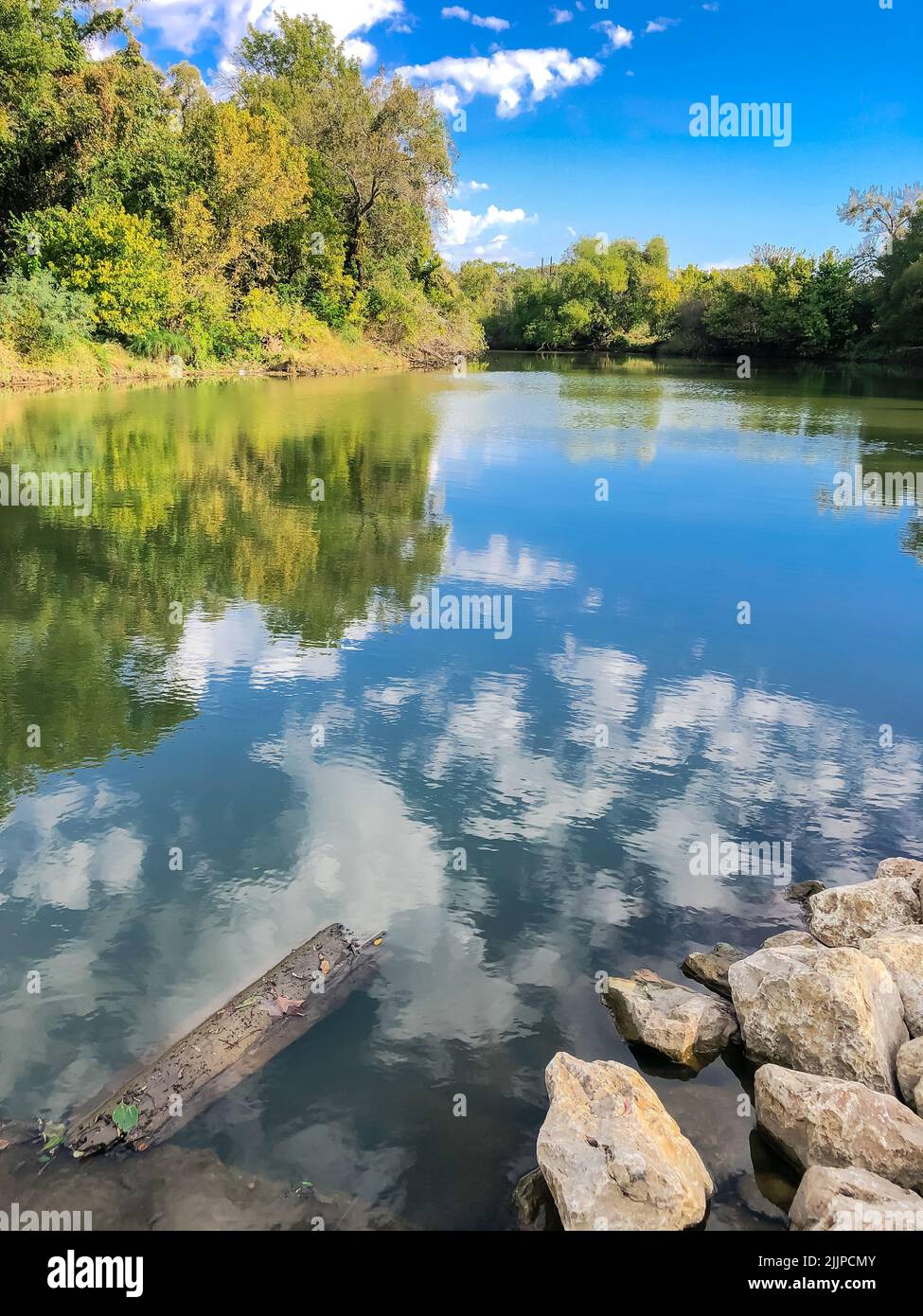 A vertical shot of Denton Creek Trinity River reflecting the sky, Dallas, Texas, America. Stock Photo