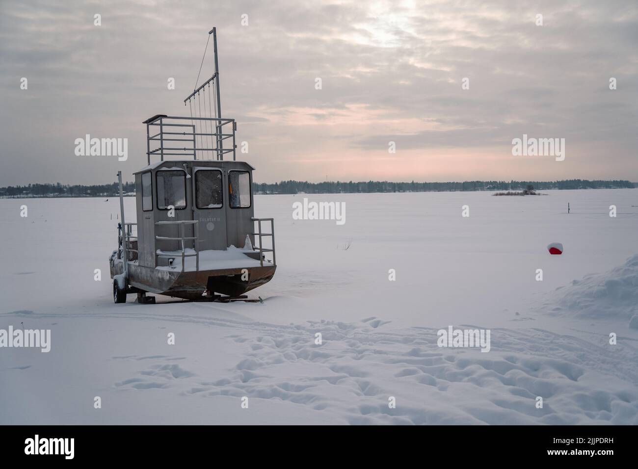 A closeup shot of a small boat in a frozen lake in Jarvenpaa, Finland Stock Photo