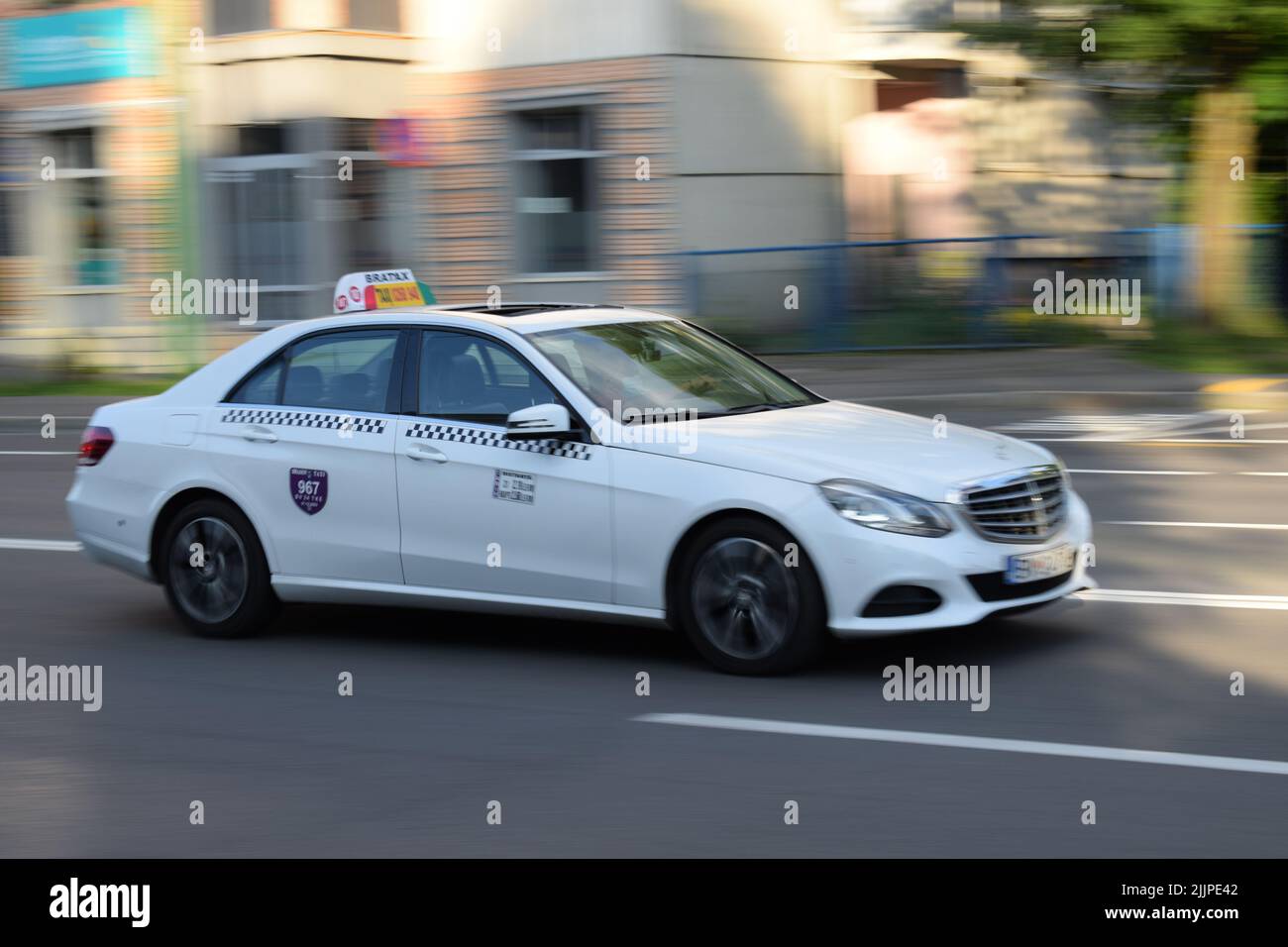 A white Mercedes-Benz taxi car on the street in Brasov, Romania, in summer Stock Photo