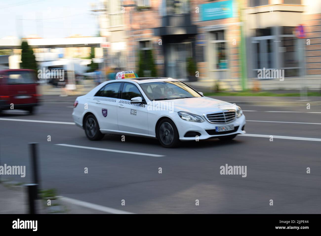 A white Mercedes-Benz taxi car on the street in Brasov, Romania, in summer Stock Photo