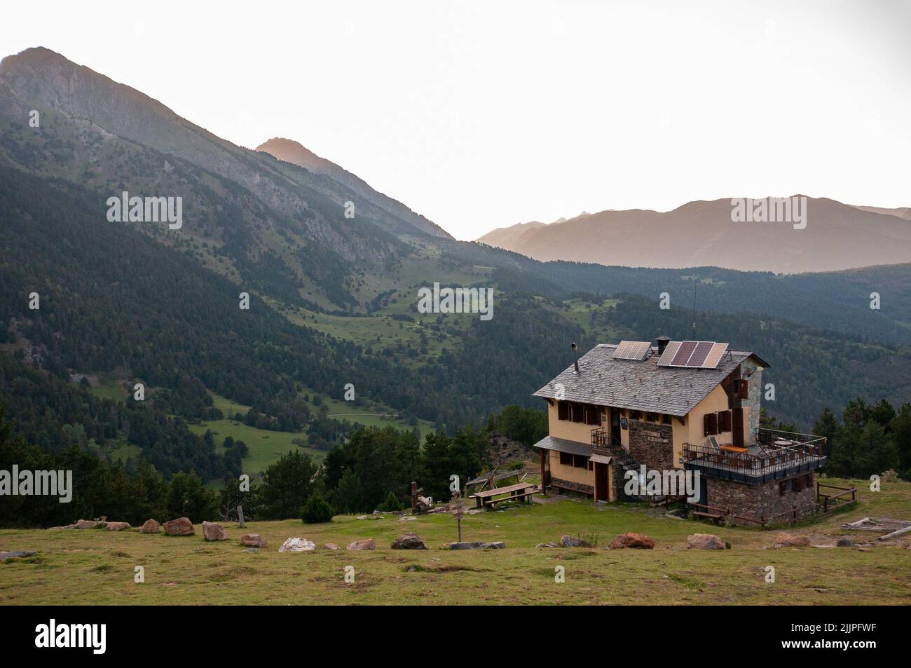 A lone house at a remote area surrounded by mountains Stock Photo