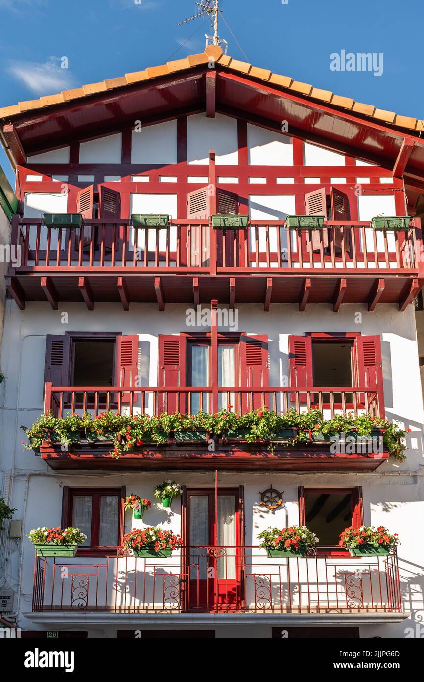A vertical shot of the beautiful house with green plants in the balconies in Hondarribia, Spain Stock Photo