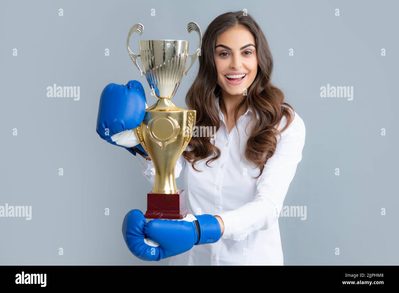 Woman in boxing gloves hold champion winner cup, trophy. Excited win
