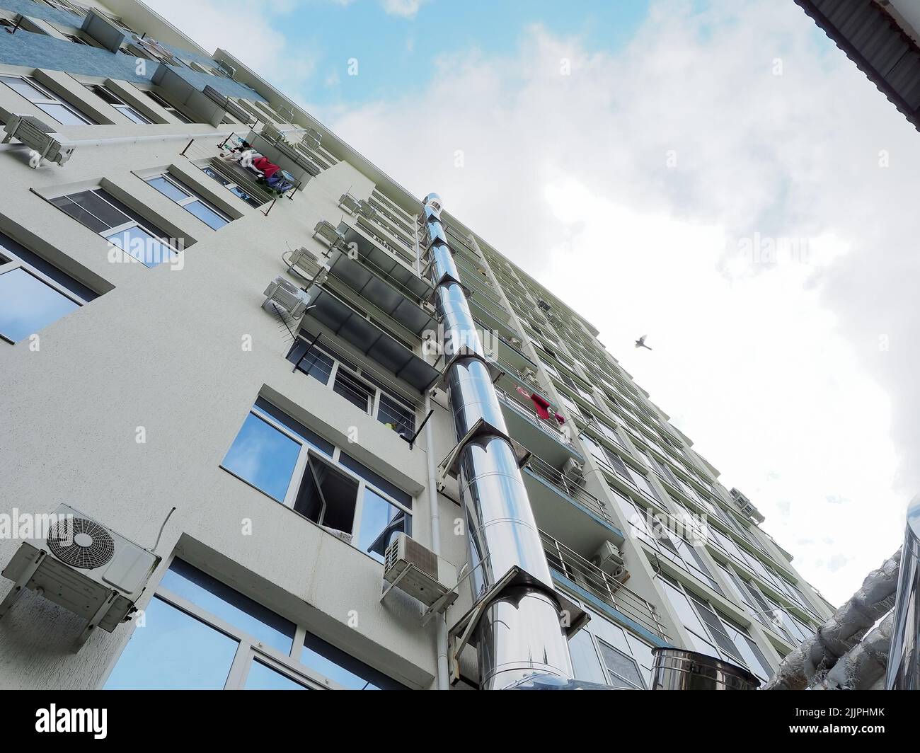 Iron exhaust pipe on the wall of a multistorey building. Maintenance
