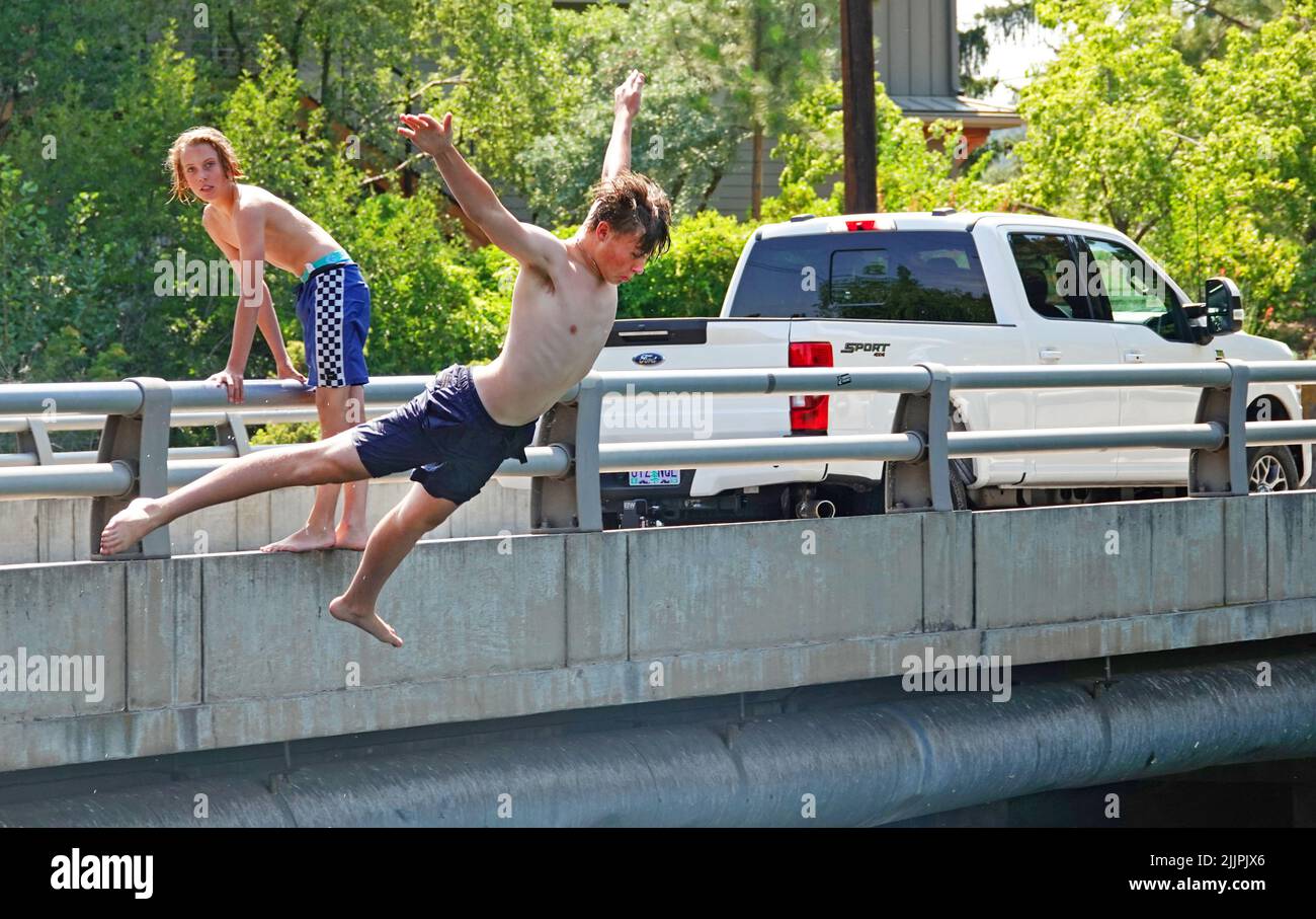 Young boys cool off by diving into  the Deschutes River in Bend, Oregon, trying to escape the 100 degree F heatwave that is sweeping the Pacific Northwest. Stock Photo