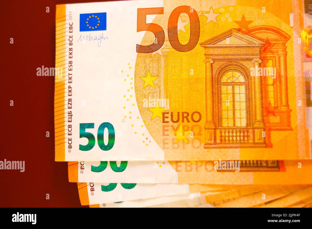 Money background.fifty euros banknotes pack set on a brown burgundy background.Income and expenses in the EU countries. Stock Photo