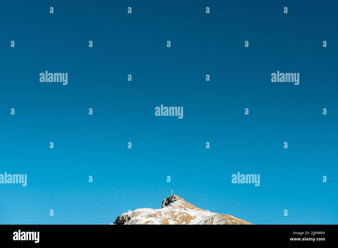 The clear sky with gradient blue effect and a summit peeking below Stock Photo