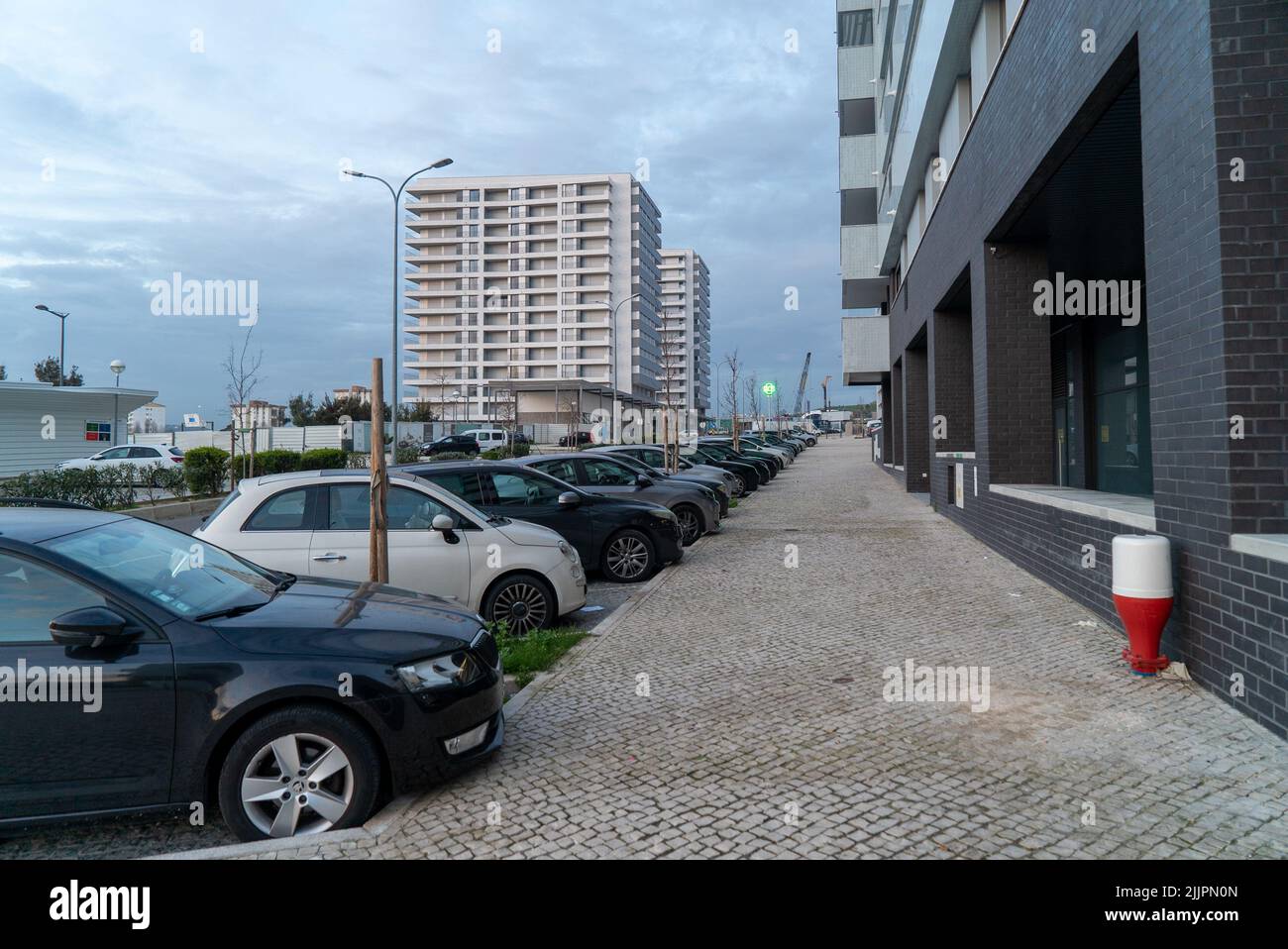 A street with parked cars surrounded by similar buildings during the day in Lisbon, Portugal Stock Photo