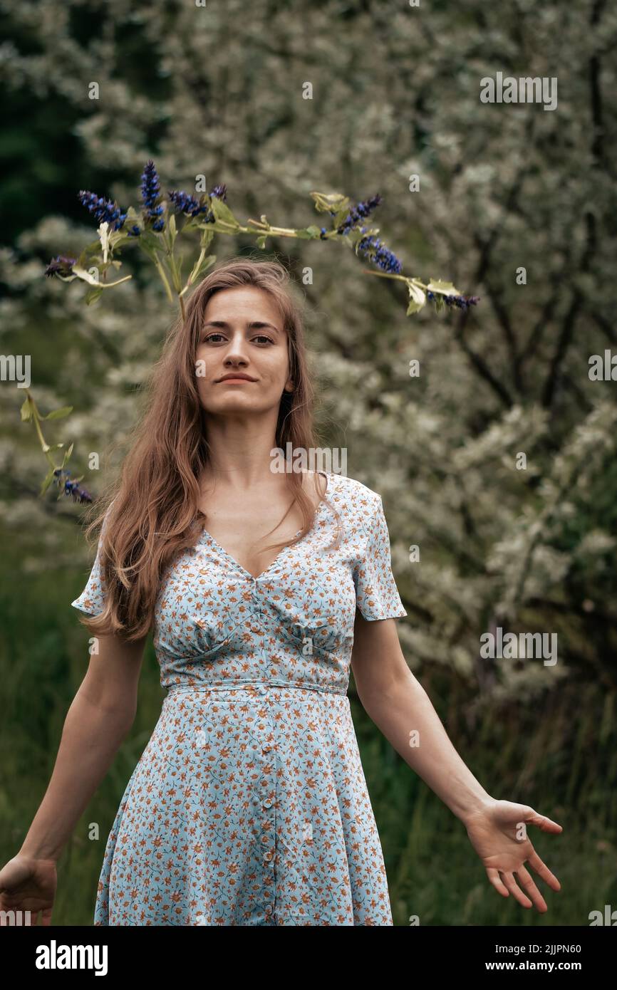 A beautiful young Caucasian girl with long hair in a floral dress ...