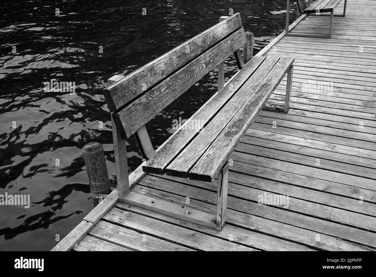 An old wooden bench on a platform in a lake Stock Photo