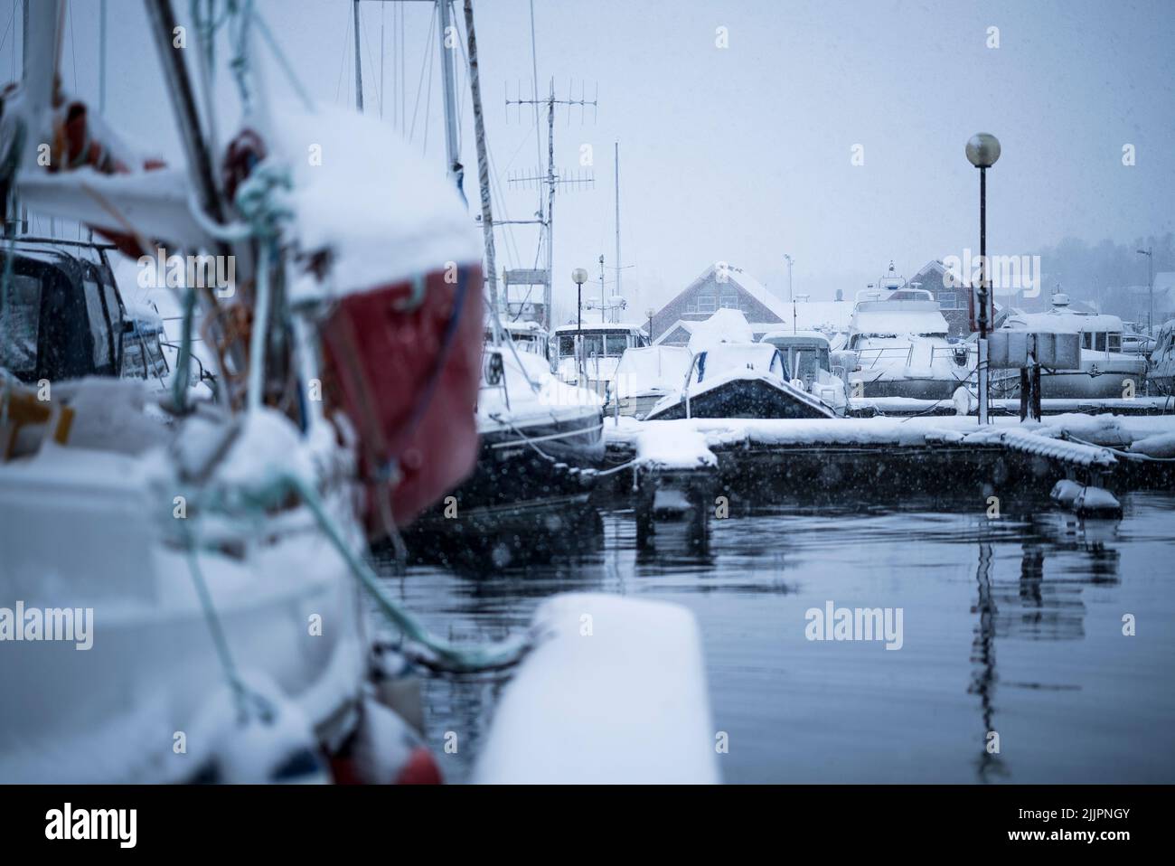 A harbor in Tromsdalen, Norway with boats in winter Stock Photo