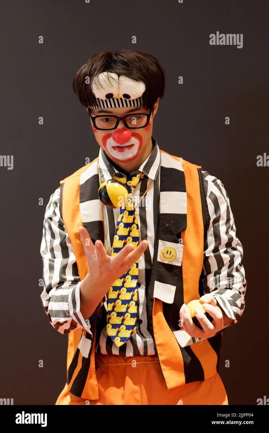 A male clown juggling balls at birthday party Stock Photo - Alamy