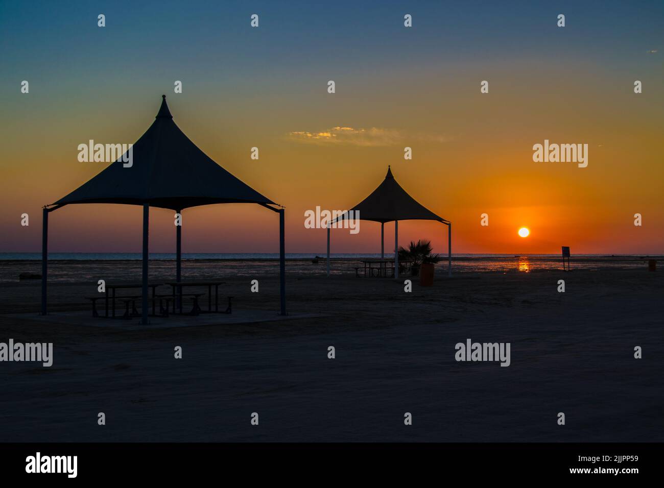 A sunset on the beach with tents Stock Photo - Alamy