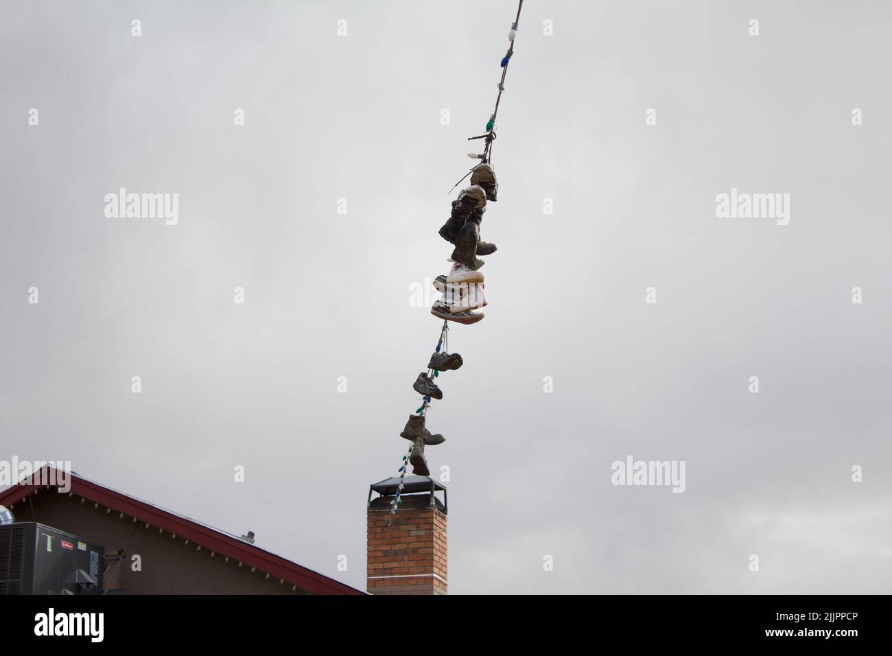 A closeup of shoes hanging from a rope Stock Photo