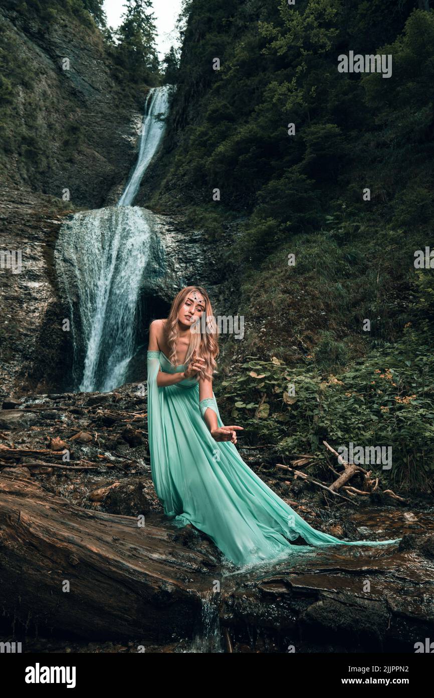 A vertical fashion editorial shot of a young female in a flowy green dress posing near a waterfall Stock Photo - Alamy A vertical fashion editorial shot of a young female in a flowy green dress posing near a waterfall Stock Photo - Alamy