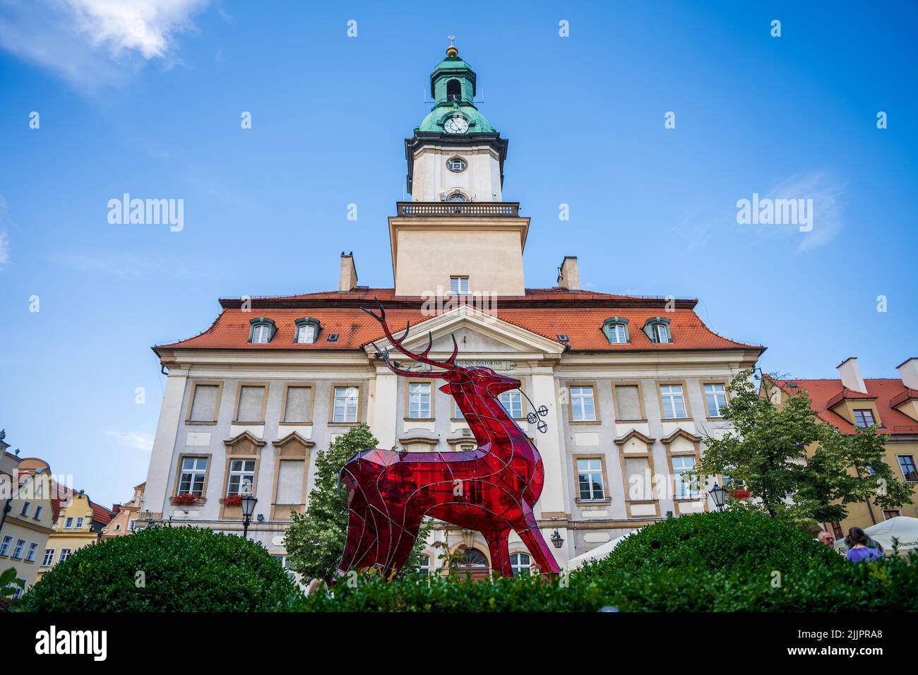A low angle shot of Town Hall in Jelenia Gora behind red glass deer Stock Photo