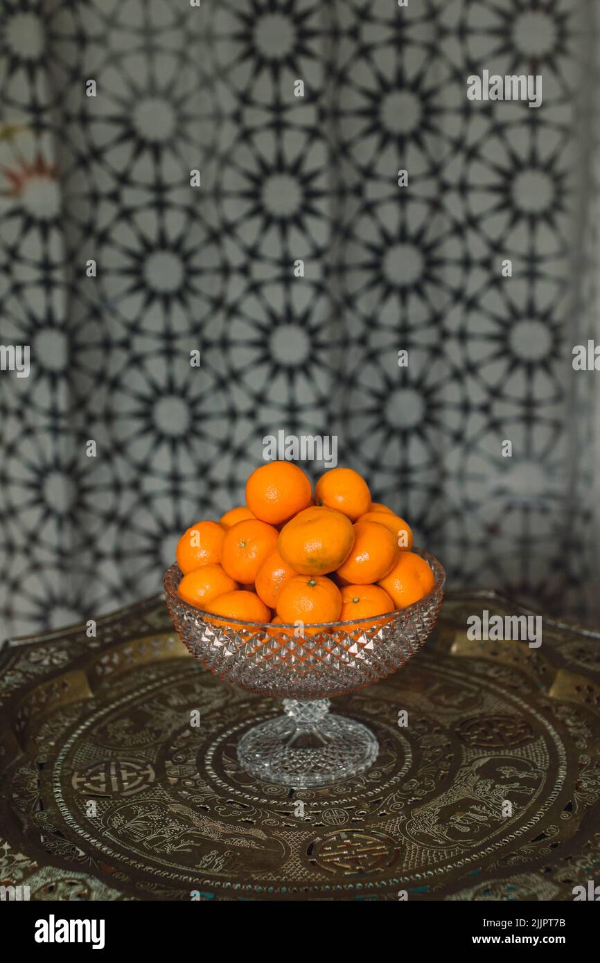 pile of tangerines, satsumas, mandarins oranges in crystal hobnail bowl