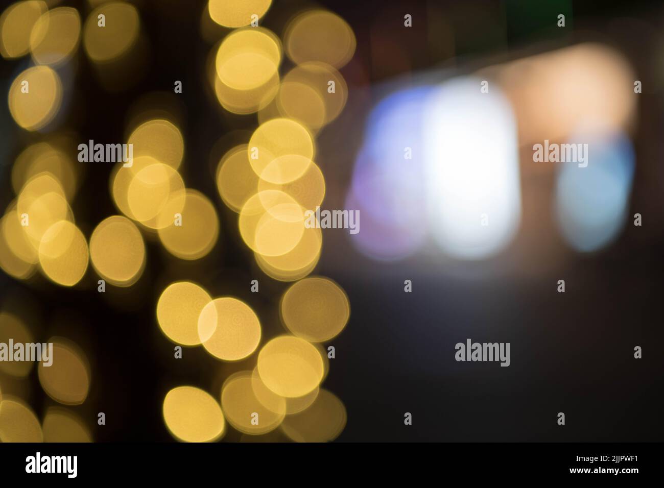 Blurry Decorative outdoor string lights on tree in the garden at night. Bokeh. Christmas light on tree. For background and designing Stock Photo