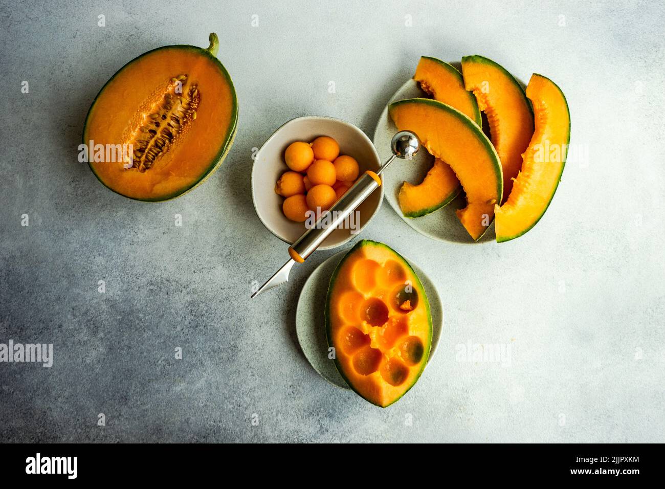 Overhead view of slices of cantaloupe melon and melon balls on a table Stock Photo