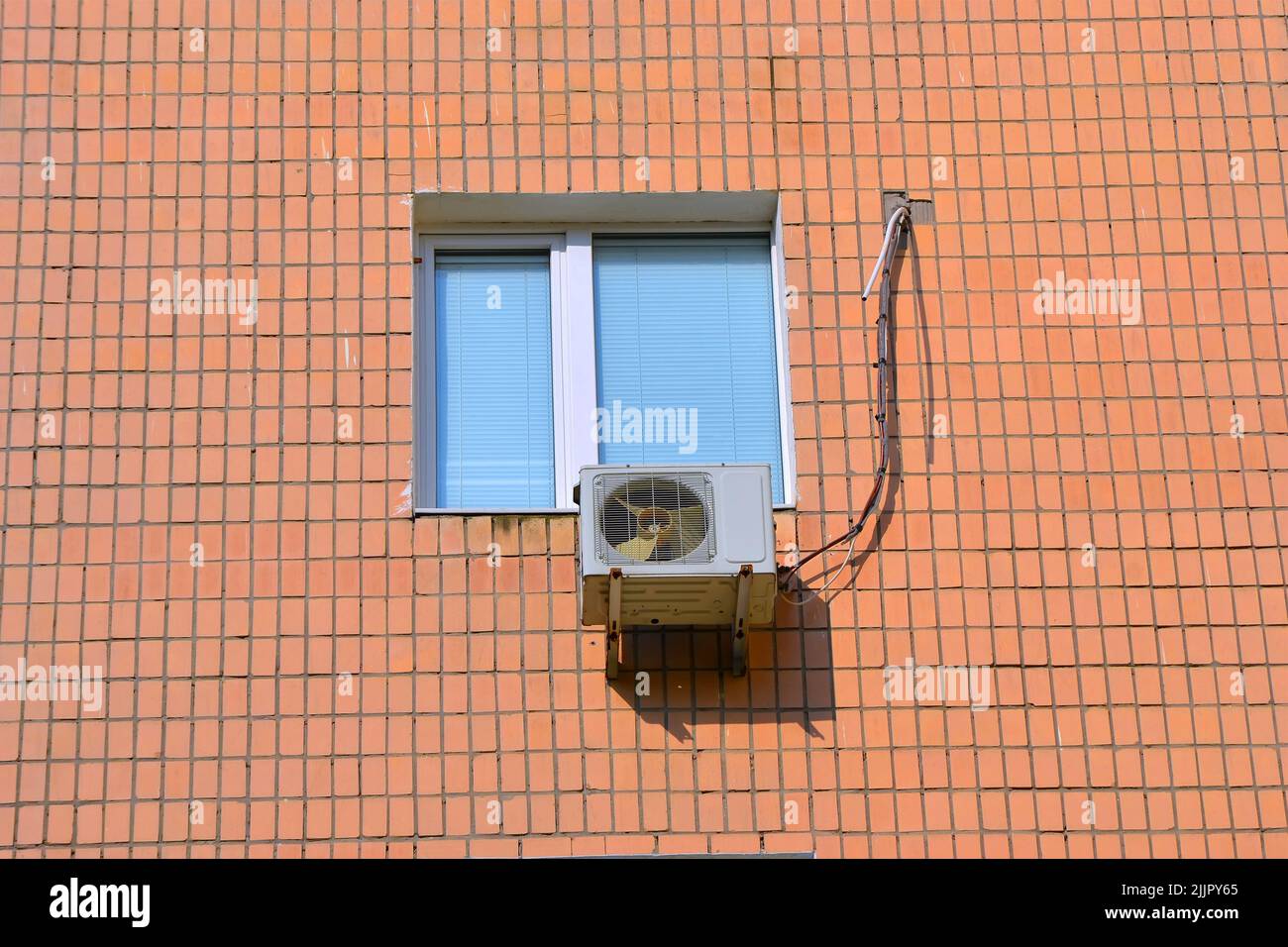 air cooler (modern conditioning device) under closed window with blinds