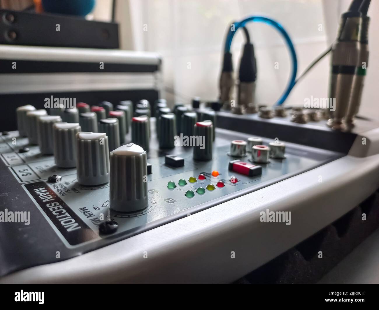 A closeup of a grey and white mixing console (desk) for sound and music ...