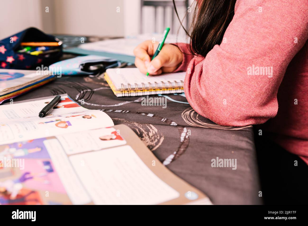 A young girl doing her homework on the table at home Stock Photo