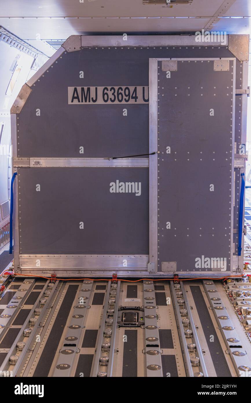 A vertical shot of cargo box on rails inside a 747-8F freight aircraft ...